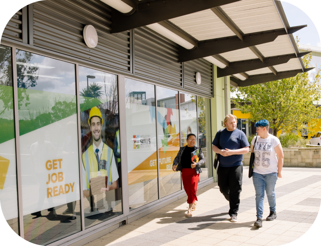 Students walking outside the Industry Skills Training campus, showcasing the vibrant student life and community at IST.