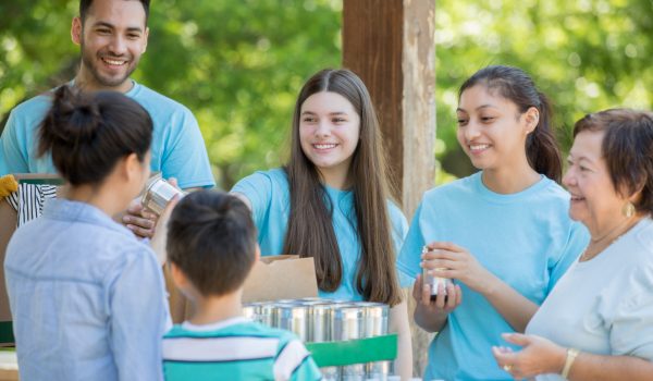 Diverse group of volunteers accepting donations at community food drive